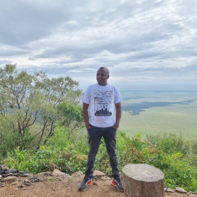Keshi Tours Director John posing for a photo at the Great Rift Valley escarpment viewpoint in Kenya